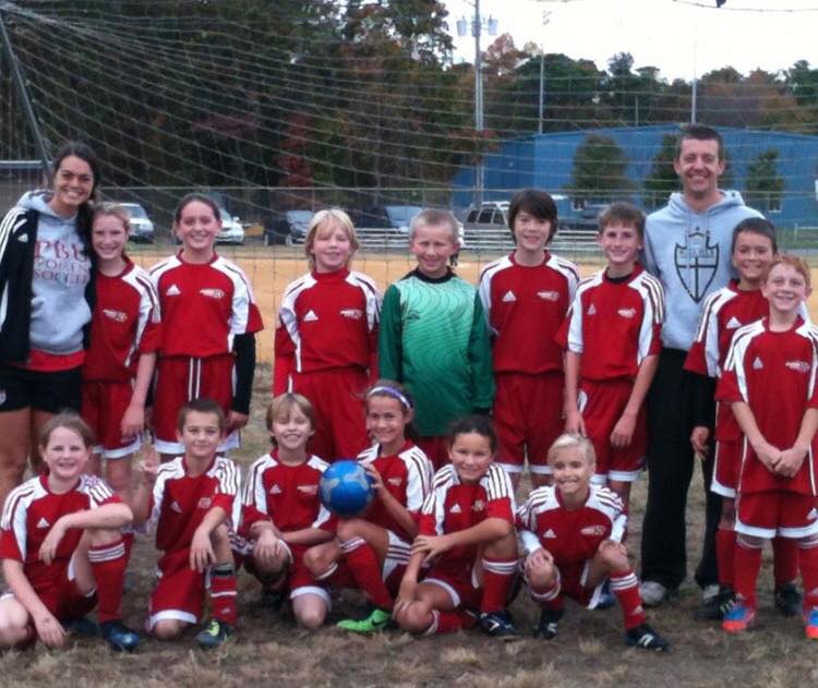 Soccer team in red and white posing for team photo