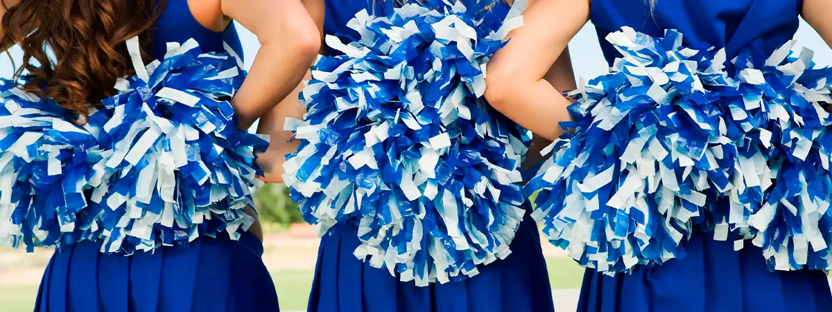Three cheerleaders holding pompoms on their backs.